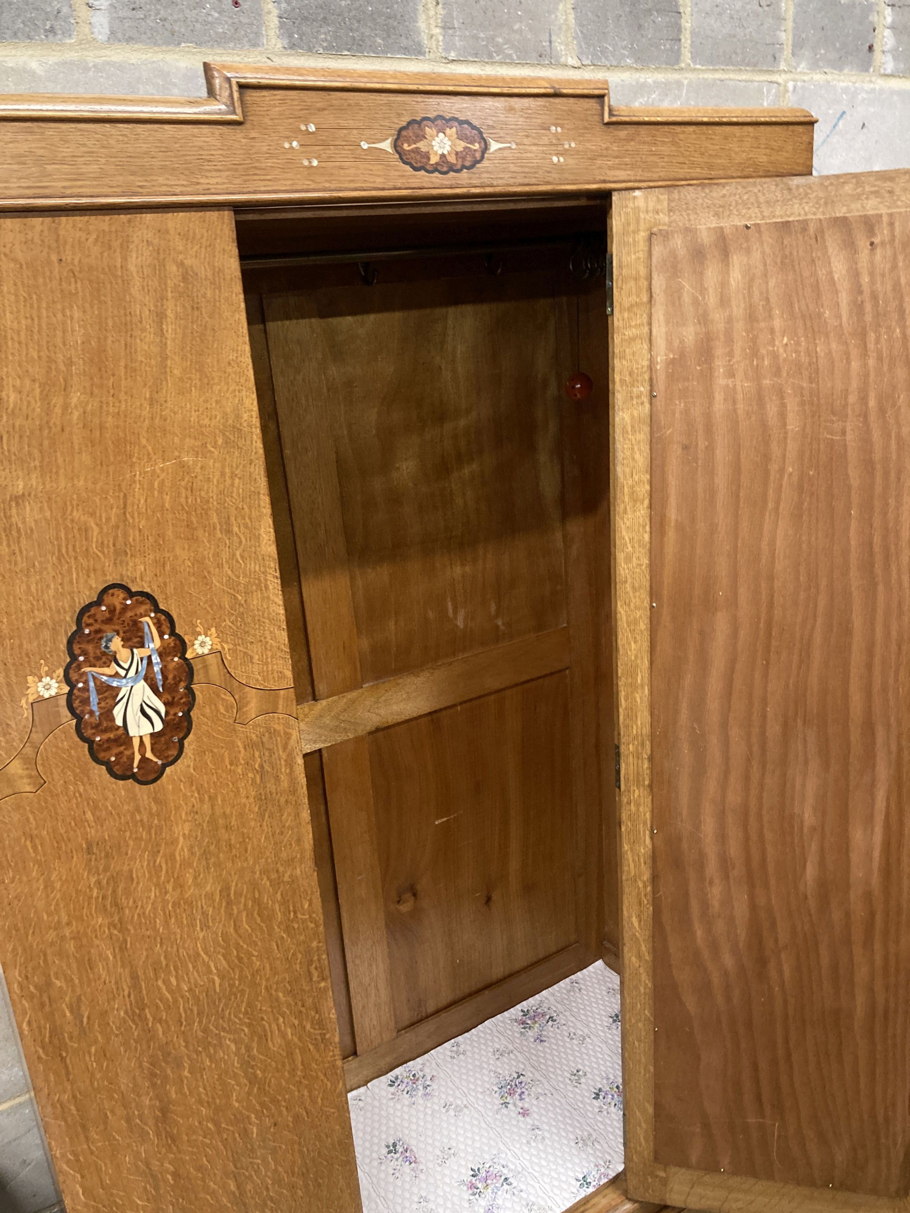 An early 20th century inlaid oak three piece bedroom suite, wardrobe width 106cm, depth 43cm, height 193cm